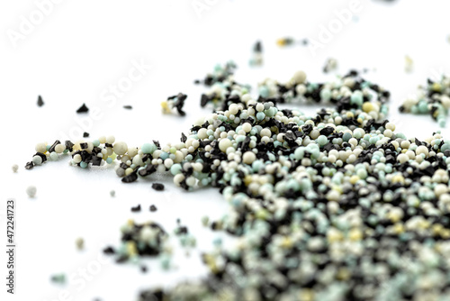 A background made out of strewn inside an activated carbon filter and water filter balls, isolated on a white background, selective focus in the center.