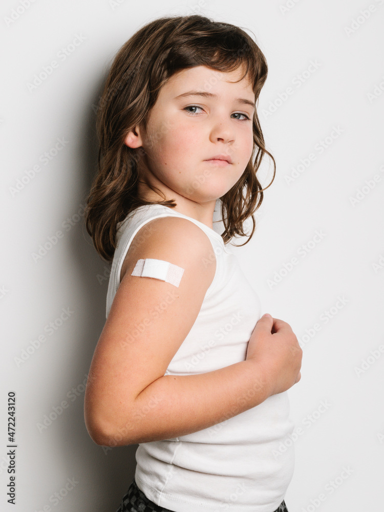Serious vaccinated girl with band aid on arm Serious vaccinated girl with band aid on arm