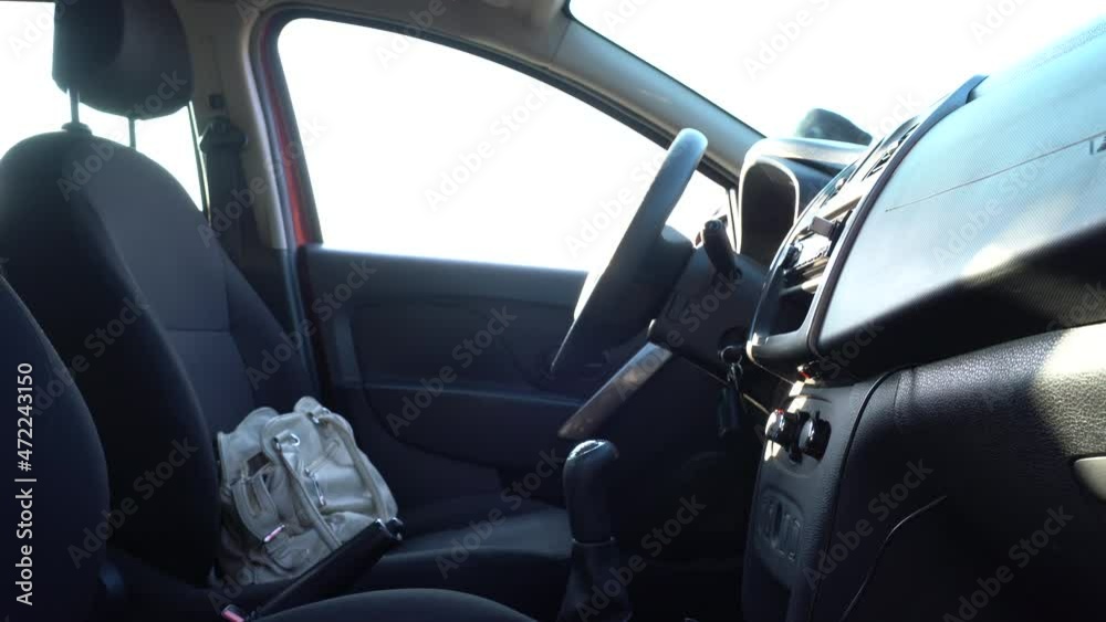 a man in a black hoodie and black glasses steals a bag from the seat of someone else's car. transportation, crime and ownership concept a man in a black hoodie and black glasses steals a bag from the seat of someone else's car. transportation, crime and ownership concept