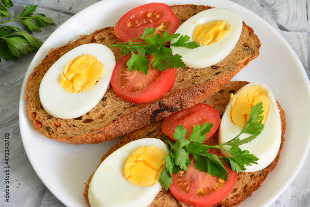 healthy sandwiches with boiled eggs, tomatoes and parsley, close-up