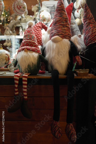 The atmosphere of festive mood of anticipation. Funny stuffed toy gnome elf with the long beard and striped cap, sitting at the Christmas market Wroclaw.