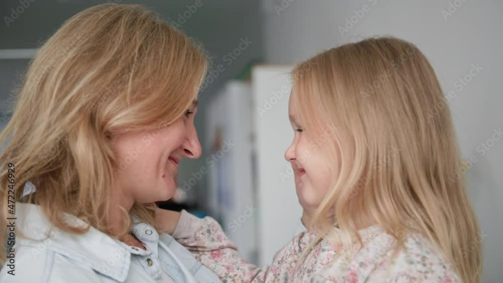 motherhood, happy cute little girl hugs her caring mother tenderly while relaxing at home motherhood, happy cute little girl hugs her caring mother tenderly while relaxing at home