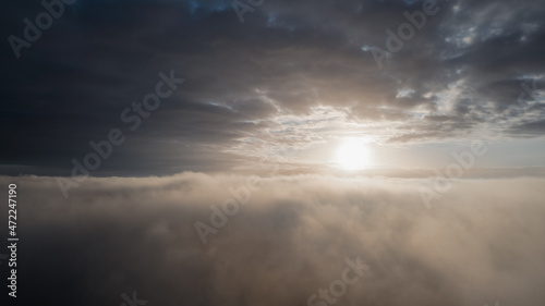 Fly Above the mist between the Clouds During Sunrise. Flying Drone Into the Misty Clouds at Evening. Aerial Drone Shoot. High quality photo