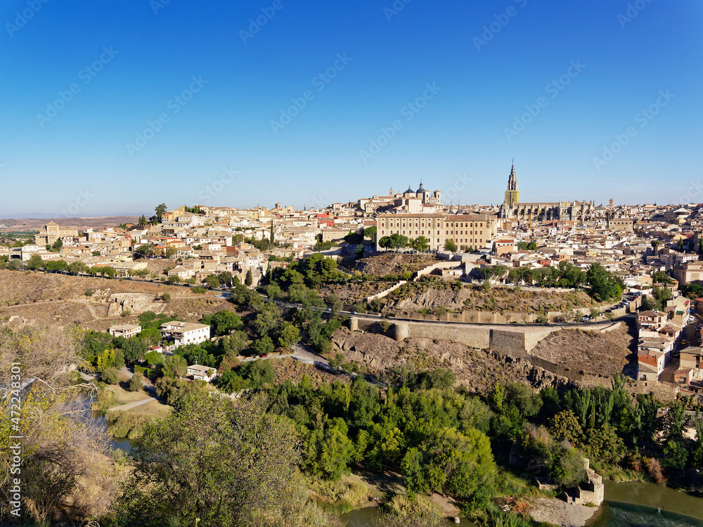 The scenery of Toledo city in Spain with the old and historic buildings which is the UNESCO World Heritage Site with the trees and the Tagus river are in the foreground.
