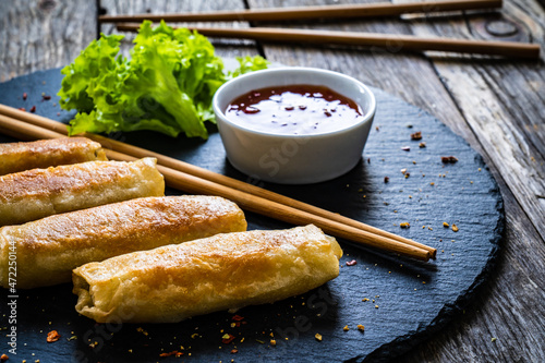 Spring rolls on stone plate on wooden table photo