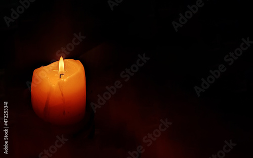 Funeral candle flame candlelight on dark background photo