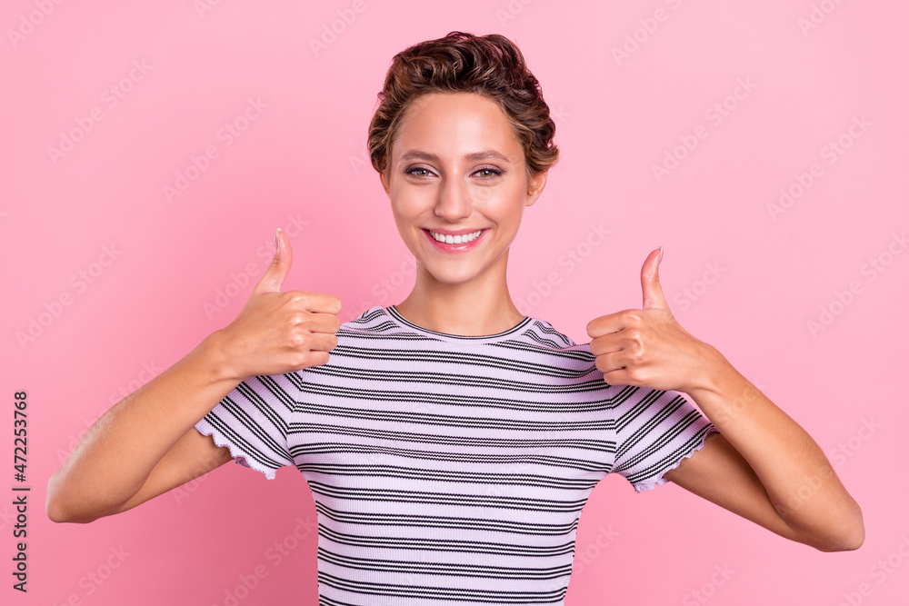 Photo of cool young short hairdo lady show thumb up wear striped t-shirt isolated on pink color background Photo of cool young short hairdo lady show thumb up wear striped t-shirt isolated on pink color background