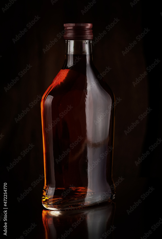 A small flat bottle with an alcoholic beverage