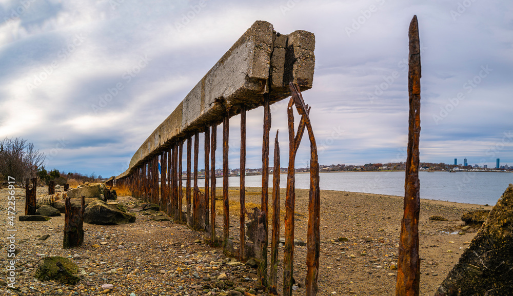 Old rusty broken cement hurricane barriers on the beach. Remains of archaic structures of the marina in Quincy, Massachusetts. Old rusty broken cement hurricane barriers on the beach. Remains of archaic structures of the marina in Quincy, Massachusetts.