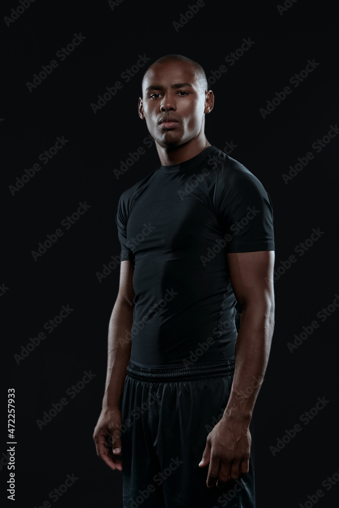 Young serious athletic black man looking at camera