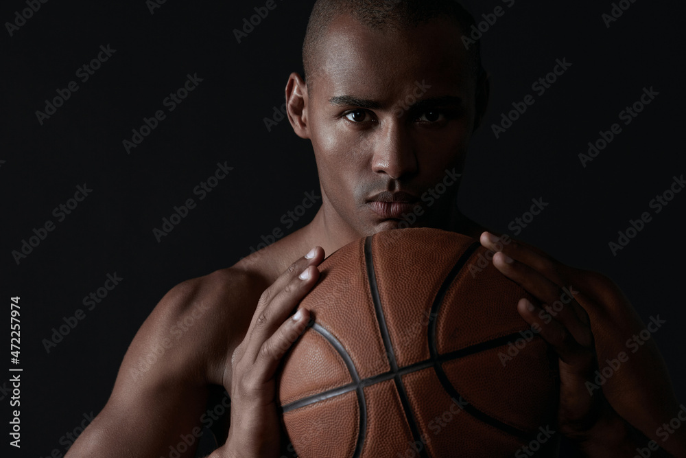 Young athletic black man holding basketball ball