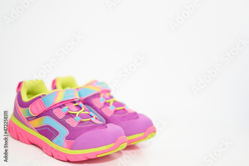 color kid sneakers shoes with shoelace on floor side view soft focus copy space
