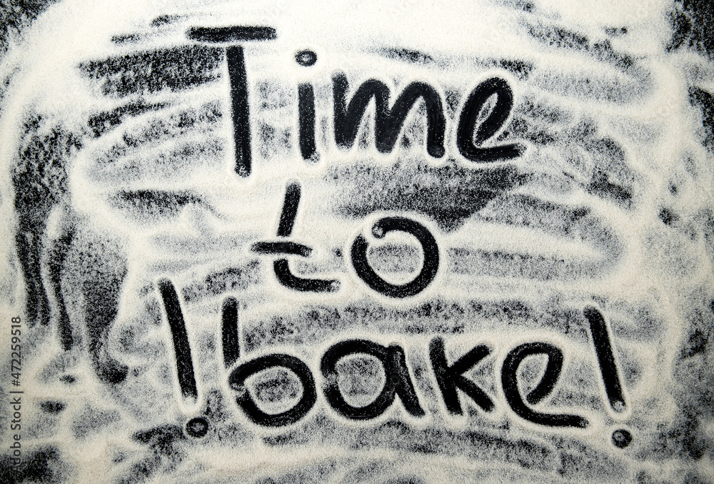 Time to bake lettering on a dark, black flour background. Background with inscription Time to bake lettering on a dark, black flour background. Background with inscription