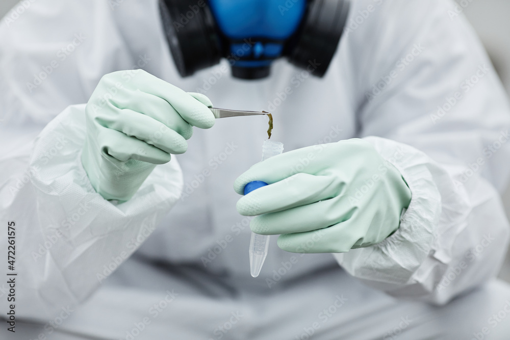 Close up of person wearing hazmat suit collecting probes, toxic waste and pollution concept, copy space Close up of person wearing hazmat suit collecting probes, toxic waste and pollution concept, copy space