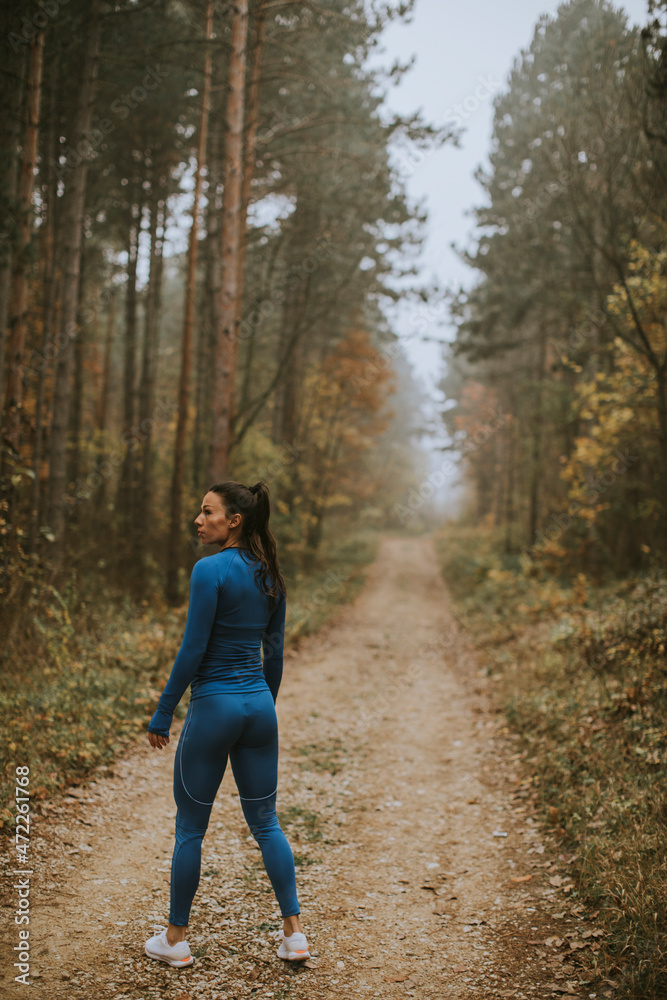 Young woman take a break during outdoor exercise on the forest trail at autumn Young woman take a break during outdoor exercise on the forest trail at autumn