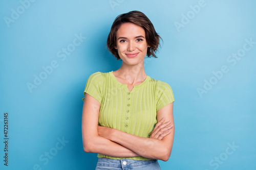 Photo of attractive confident young lady wear green t-shirt smiling arms crossed isolated blue color background photo