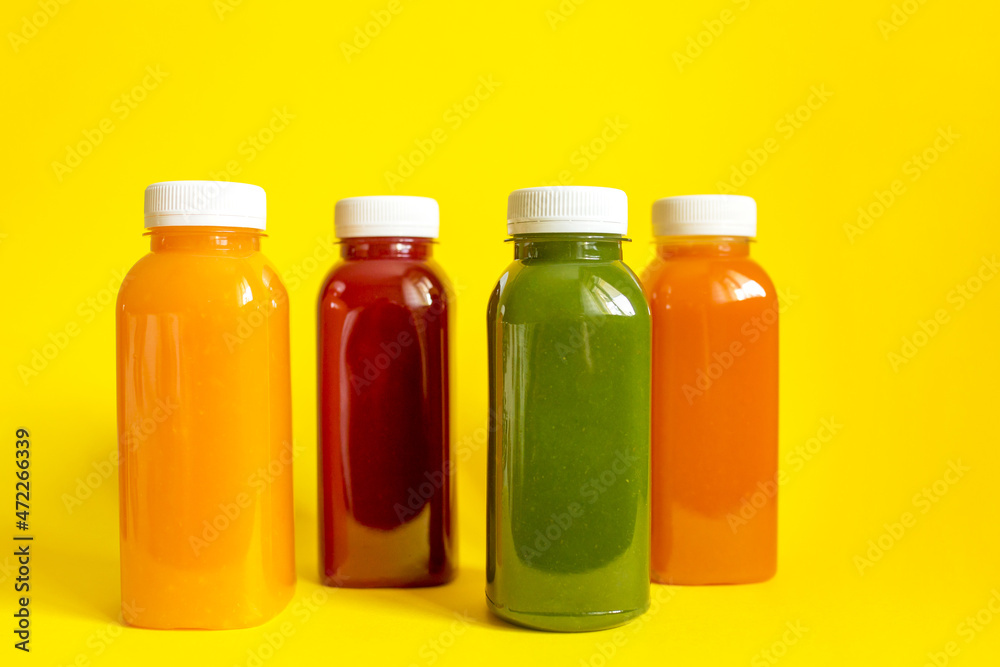 Fresh juices or smoothies of fruits and vegetables in bottles on a yellow background. The concept of a healthy diet, diet or detox. Flat lay, top view Fresh juices or smoothies of fruits and vegetables in bottles on a yellow background. The concept of a healthy diet, diet or detox. Flat lay, top view