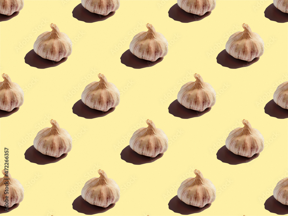 Garlic heads on a yellow background. healthy food, background, pattern, design
