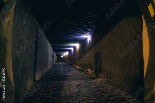 underground grunge tunnel dirty urban exploration place at night with lighting lamps illumination, unfocused and slightly fuzzy concept picture with perspective foreshortening