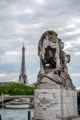 Statue of a Lioin on Bridge Alexandre III, view to Eiffel tower, Paris © imagoDens