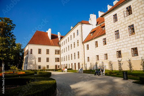 Trebon, South Bohemia, Czech Republic, 9 October 2021: Castle Courtyard, Renaissance chateau with tower and sgraffito mural decorated plaster at facade at sunny day, medieval historical town with park