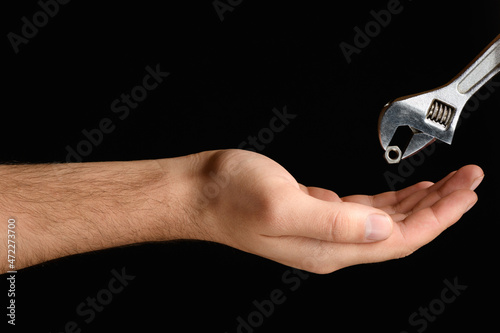 Carob wrench as it puts the nut in the palm close-up black background isolate