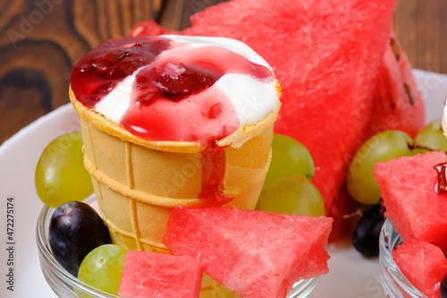 white ice cream in a waffle cup with grapes and watermelon