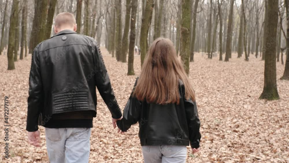 Happy young couple in love walking in autumn park, hugging, kissing and having fun Happy young couple in love walking in autumn park, hugging, kissing and having fun