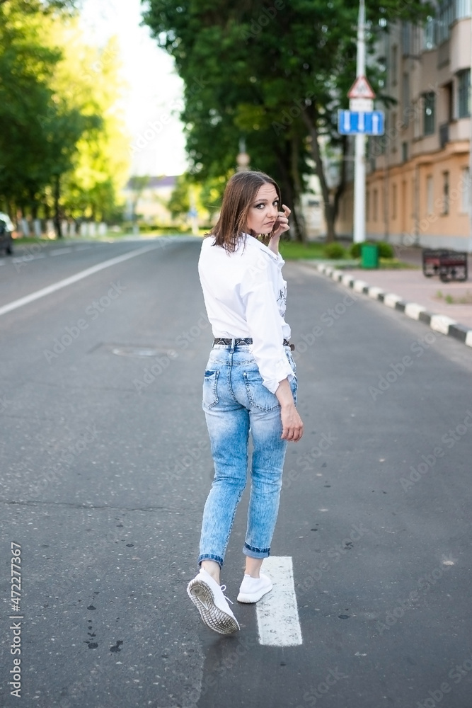 Beautiful girl in jeans and a white blouse. Beautiful girl in jeans and a white blouse.
