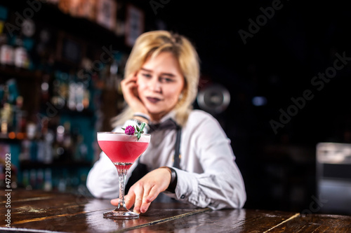 Girl barman formulates a cocktail in the beerhall