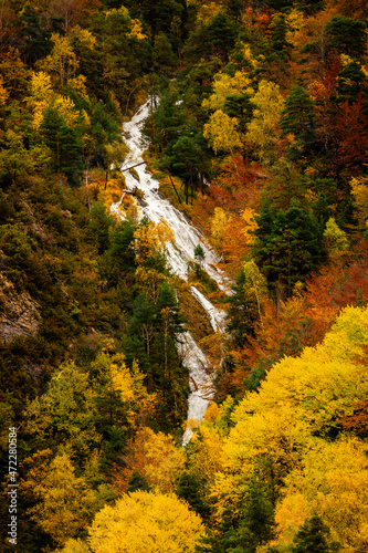 Mountain waterfall through an autumn-colored forest