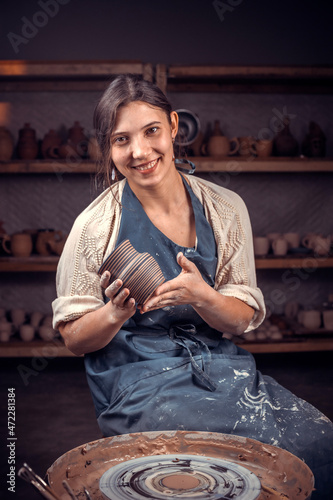 Pottery master demonstrates the finished clay product in a pottery workshop. Handcraft.