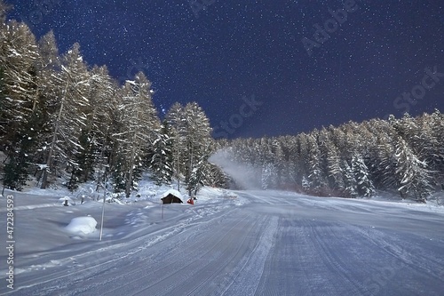 Skiing slope at night below starry sky