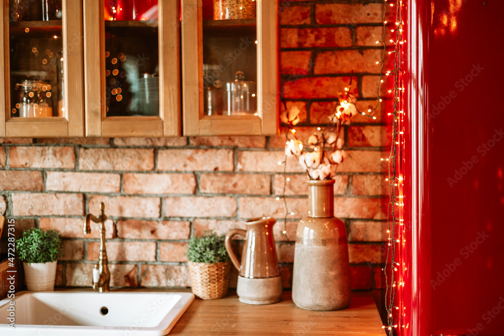 kitchen in authentic stylish chalet decorated for Christmas or New Year eve dinner, details of a cozy kitchen interior with a brick wall