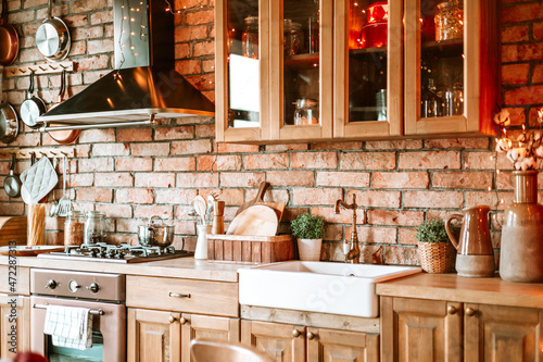 kitchen in authentic stylish chalet decorated for Christmas or New Year eve dinner, details of a cozy kitchen interior with a brick wall