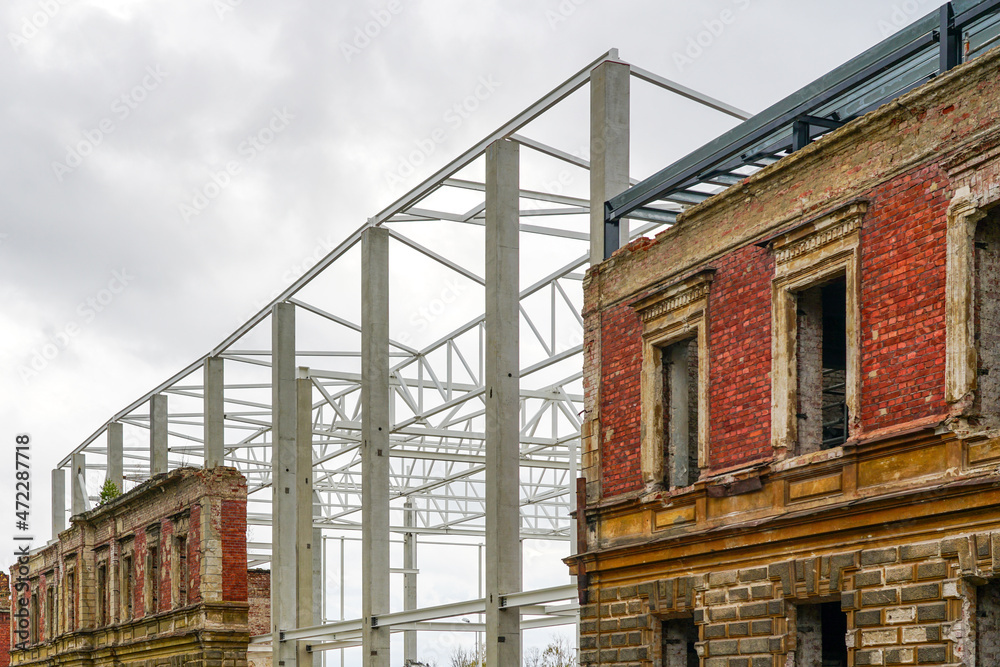 integration of the facade of the old building into the new metal construction housing