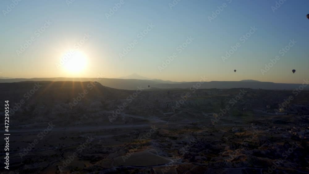 Cappadocia, Turkey: Drone shot of many hot air balloon flying over idyllic Love Valley in natural park, landmark or landscape of Goreme against rocky hill terrain and sunrise or sunset Cappadocia, Turkey: Drone shot of many hot air balloon flying over idyllic Love Valley in natural park, landmark or landscape of Goreme against rocky hill terrain and sunrise or sunset