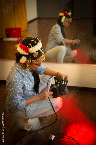 Bharatanatyam dancer fixing a light in her studio