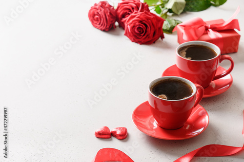 Valentine's day dating with coffee, red chocolate sweets and roses on white background. Close up. Romantic date for two.