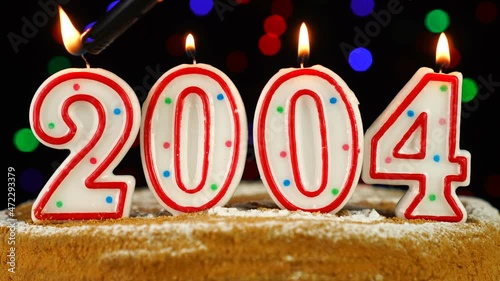 Birthday cake with white burning candles in the form of number 2004