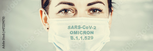 New African variant of the coronavirus. Mask on the woman face with the inscriptions SARS COV 2 Omicron. Wide banner. photo