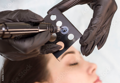 Permanent makeup. Permanent eyebrow tattoo. Cosmetologist applying permanent makeup on eyebrows - eyebrow tattoos. Tattooing. Microblading.