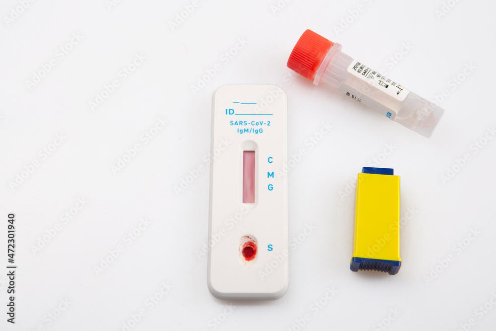 isolated shot of a rapid express antigen antibody coronavirus covid-19 pandemic test sample with blood, a lancet vial and a solution on white background isolated shot of a rapid express antigen antibody coronavirus covid-19 pandemic test sample with blood, a lancet vial and a solution on white background