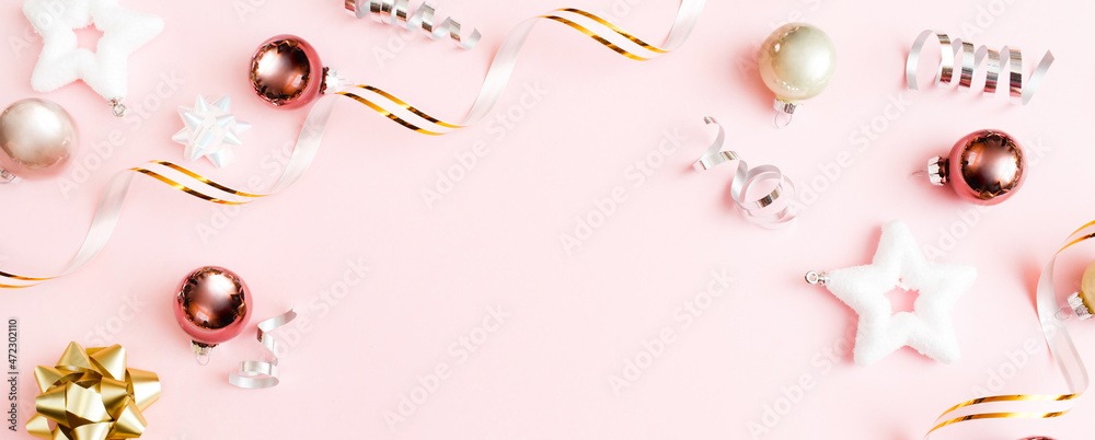 Fototapeta premium Christmas Banner made of decoration on pastel pink background. New Year greeting card. Flat lay, top view, copy space.
