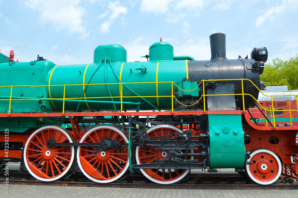 Old steam locomotive 1935-1957 Green with red wheels. Renovated, it stands on the railway as a museum piece.