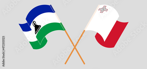 Crossed and waving flags of Kingdom of Lesotho and Malta