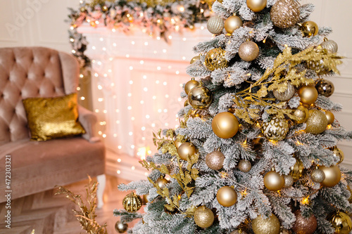 The Christmas tree is decorated with golden toys for the new year.