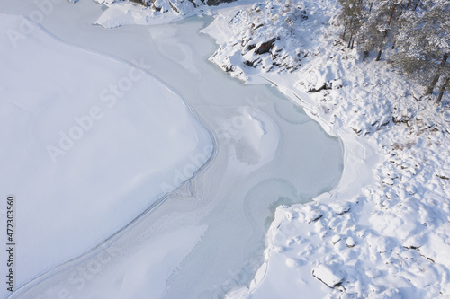 Above view of frozen river patterns covered by in winter