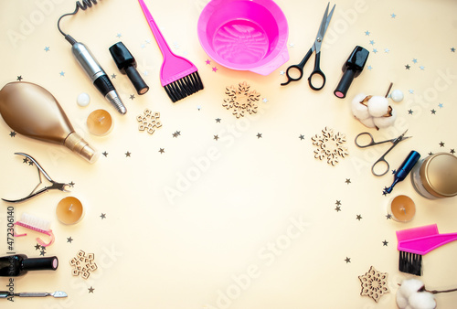 Christmas composition of hairdressing tools and accessories for manicure, pedicure and makeup on a beige background, flat lay. Varnishes, wire cutters, scissors, manicure machine, brushes for home and