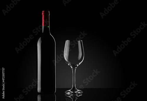wine bottle with a goblet on a black background